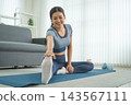 Active Asian Woman Exercising, Stretching and Tracking Fitness During a Healthy Home Workout 143567111