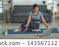 Active Asian Woman Exercising, Stretching and Tracking Fitness During a Healthy Home Workout 143567112