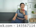 Active Asian Woman Exercising, Stretching and Tracking Fitness During a Healthy Home Workout 143567114