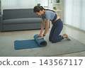 Active Asian Woman Exercising, Stretching and Tracking Fitness During a Healthy Home Workout 143567117