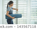 Active Asian Woman Exercising, Stretching and Tracking Fitness During a Healthy Home Workout 143567118