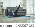 Active Asian Woman Exercising, Stretching and Tracking Fitness During a Healthy Home Workout 143567123
