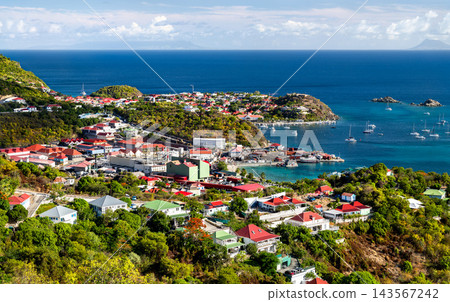 Aerial view of coastal houses, harbor facilities and boats on the turquoise sea in Gustavia, Saint Barthelemy, a French Caribbean Island Aerial view of coastal houses, harbor facilities and boats on the turquoise sea in Gustavia, Saint Barthelemy, a French Caribbean Island 143567242