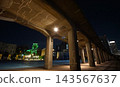 The Kanagawa Prefectural Government Building, illuminated by green lights, visible beyond the overpass at night. 143567637