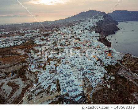 Aerial Drone View of Oia, Santorini. A breathtaking aerial view of the whitewashed village of Oia, Santorini, showcasing luxury resorts with infinity pools overlooking the Aegean Sea. A stunning blend Aerial Drone View of Oia, Santorini. A breathtaking aerial view of the whitewashed village of Oia, Santorini, showcasing luxury resorts with infinity pools overlooking the Aegean Sea. A stunning blend 143568339