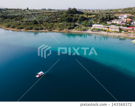 Aerial Panorama of Lake Kournas, Crete. Stunning aerial drone view of the natural Lake Kournas in Chania, Crete. The turquoise waters reflect the surrounding hills, while white pedal boats float peace Aerial Panorama of Lake Kournas, Crete. Stunning aerial drone view of the natural Lake Kournas in Chania, Crete. The turquoise waters reflect the surrounding hills, while white pedal boats float peace 143568372