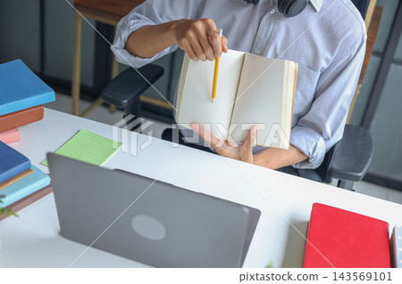 A young tutor explains a lesson during a virtual class. Concept for e-learning and online class. A young tutor explains a lesson during a virtual class. Concept for e-learning and online class. 143569101