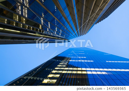 Upward perspective of illuminated office towers and corporate architecture Upward perspective of illuminated office towers and corporate architecture 143569365