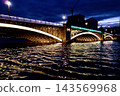The truss structure of Kuramae Bridge, emitting a fantastical light, and its reflection on the rippling surface of the Sumida River. 143569968
