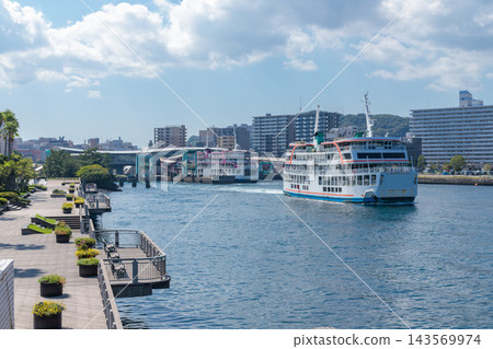 夏季從鹿兒島港的棧道上看到的渡輪碼頭和城市景色。 夏季從鹿兒島港的棧道上看到的渡輪碼頭和城市景色。 143569974