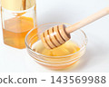 A honey jar and honey dipper, honey in a glass container 143569988