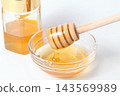 A honey jar and honey dipper, honey in a glass container 143569989