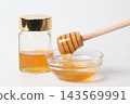 A honey jar and honey dipper, honey in a glass container 143569991