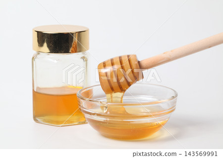 A honey jar and honey dipper, honey in a glass container 143569991
