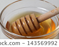 Close-up of a honey dipper soaked in honey 143569992