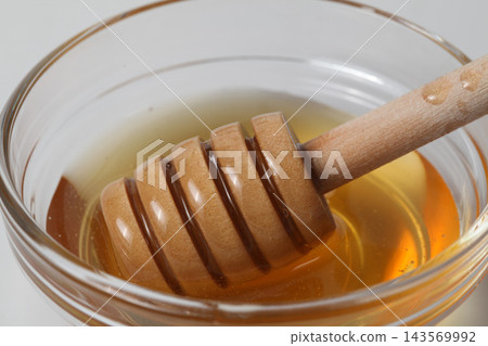 Close-up of a honey dipper soaked in honey 143569992