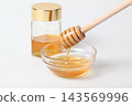 A honey jar and honey dipper, honey in a glass container 143569996