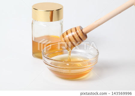 A honey jar and honey dipper, honey in a glass container 143569996