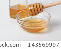 A honey jar and honey dipper, honey in a glass container 143569997