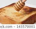 Honey toast: Drizzle honey onto toast using a honey dipper. 143570001