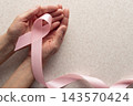 Pink Ribbon Held in Hands for Breast Cancer Awareness with Copy-space 143570424
