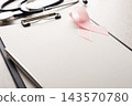 Breast Cancer Awareness Ribbon and Stethoscope on Clipboard with Copy-space 143570780