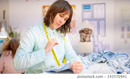 Woman working in sewing workshop preparing garment Woman working in sewing workshop preparing garment 143570941