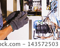 Electrician holding a circuit breaker module before installation. 143572503