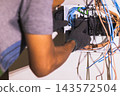 Electrician placing and adjusting circuit breakers. 143572504