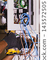 Electrician using an electric screwdriver to secure wires inside an electrical circuit. 143572505