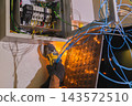 Electrician using an angle grinder with flying sparks during maintenance. 143572510