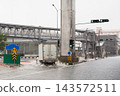 White delivery truck driving through a flooded city street during heavy rain. 143572511