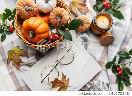 Autumn flat lay with pumpkins, candle, and warm blanket 143572538