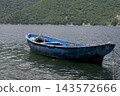Weathered Blue Wooden Fishing Boat Moored on Calm Water 143572666
