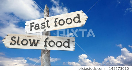 Slow food and fast food - wooden signpost with two arrows Slow food and fast food - wooden signpost with two arrows 143573010