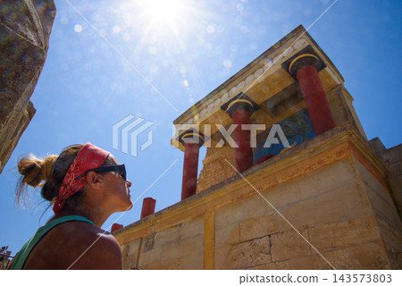 Woman exploring ancient Minoan Palace of Knossos in Crete under bright sun Woman exploring ancient Minoan Palace of Knossos in Crete under bright sun 143573803