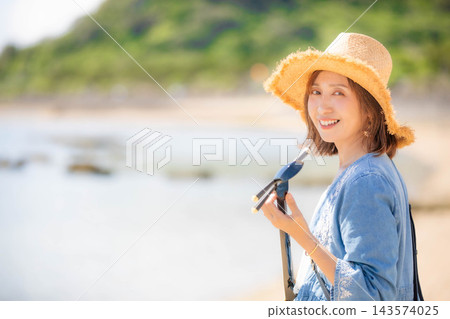 一位女模特兒在沖繩海灘上微笑。 一位女模特兒在沖繩海灘上微笑。 143574025