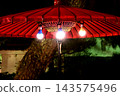 A red umbrella with a light bulb lit 143575496
