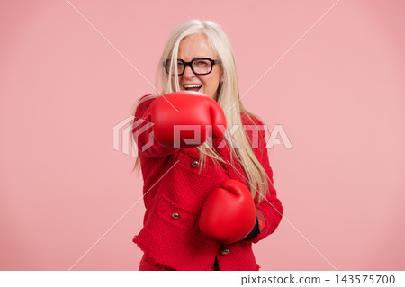 Mature woman boxing showing strength and active lifestyle Mature woman boxing showing strength and active lifestyle 143575700