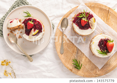 Selection of mini berry cheesecakes on plate and tray Selection of mini berry cheesecakes on plate and tray 143575779