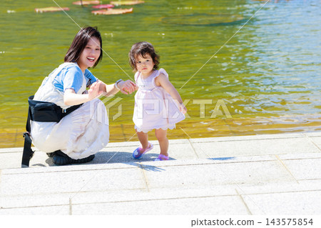 一個可愛的小女孩和媽媽在公園玩耍 一個可愛的小女孩和媽媽在公園玩耍 143575854