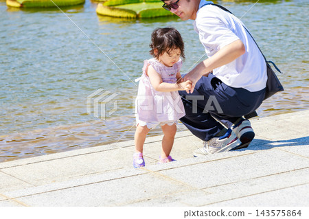 一個小女孩和她的爸爸在公園玩耍 143575864