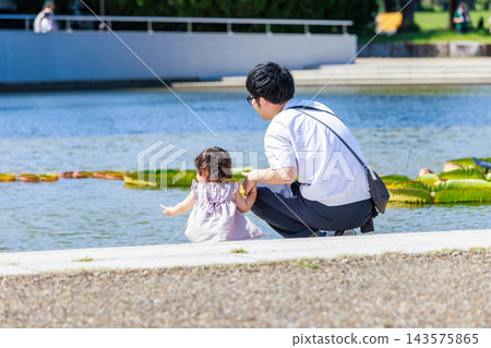 一個小女孩和她的爸爸在公園玩耍 143575865