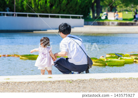 一個小女孩和她的爸爸在公園玩耍 一個小女孩和她的爸爸在公園玩耍 143575927