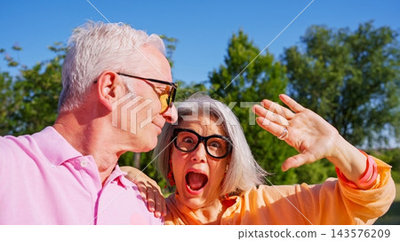 Senior couple sharing a joyful outdoor selfie moment Senior couple sharing a joyful outdoor selfie moment 143576209