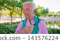 Senior man smiling holding eyeglasses enjoying outdoor park 143576224
