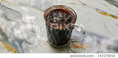 Black Coffee In Glass Mug On Wet Marble Table Outdoors Black Coffee In Glass Mug On Wet Marble Table Outdoors 143576858