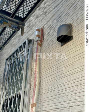 Protecting air conditioning piping during exterior wall painting work. 143576972