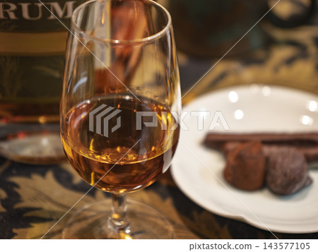 琥珀色陳年蘭姆酒與巧克力的優雅搭配。 琥珀色陳年蘭姆酒與巧克力的優雅搭配。 143577105