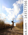 A woman dancing in an autumn park 143577566